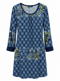 Front of Sugar Crisp SC03013 navy and lime floral print tunic with a gathered scoop neckline, roll-tab sleeves and plain navy cuffs.
